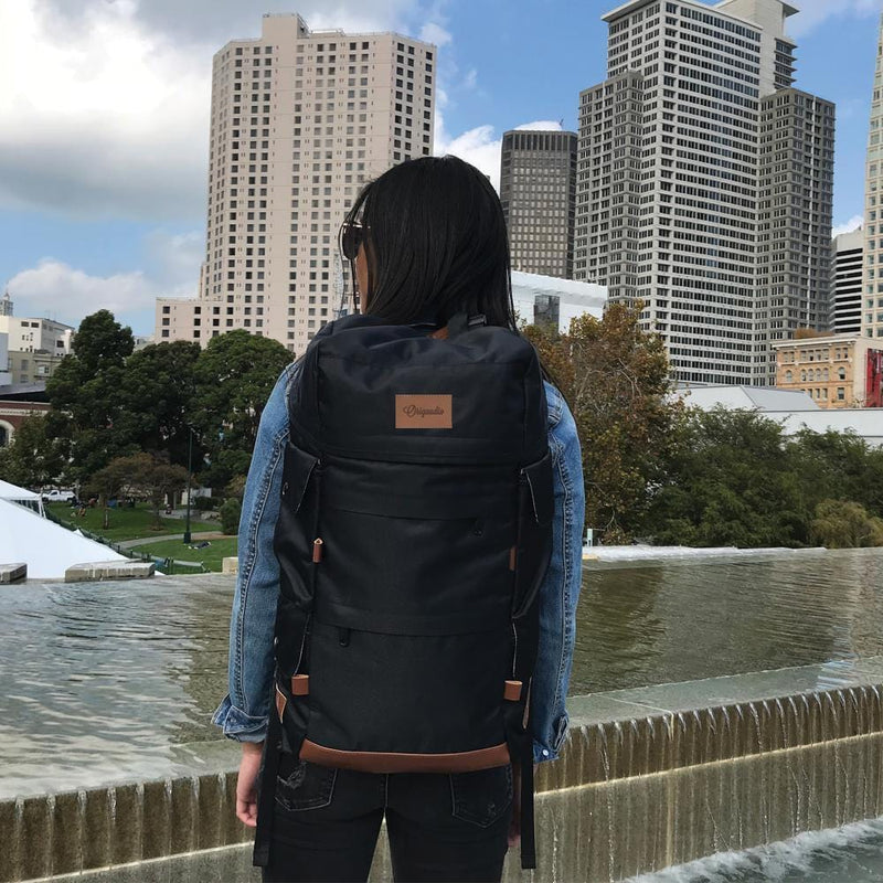A woman carries the Black Presidio Pack through the city.