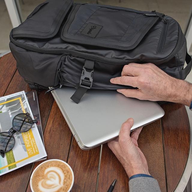A man pulls a laptop out of the Tahoe Weekender Pack.