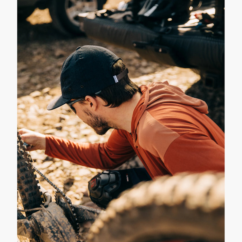 Yuba Long Sleeve Brick Hoodie on a man checking his bike tire air