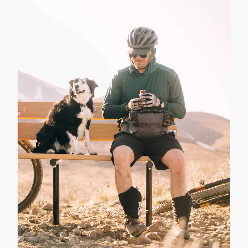 Deso Supply Company Yuba Long Sleeve Hoodie on a male mountain biker eating a snack