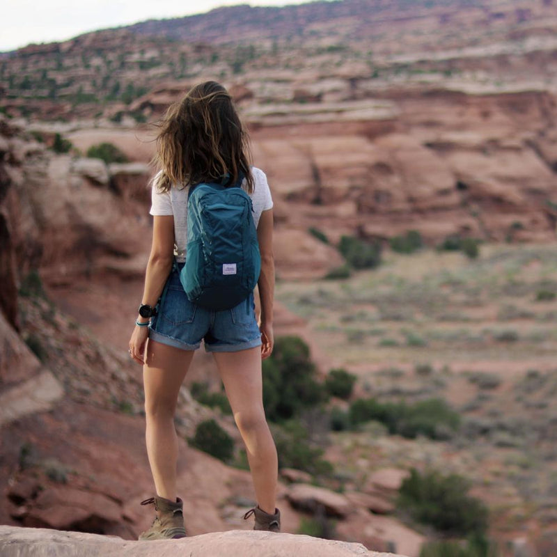 A woman wears the DL16 Backpack.