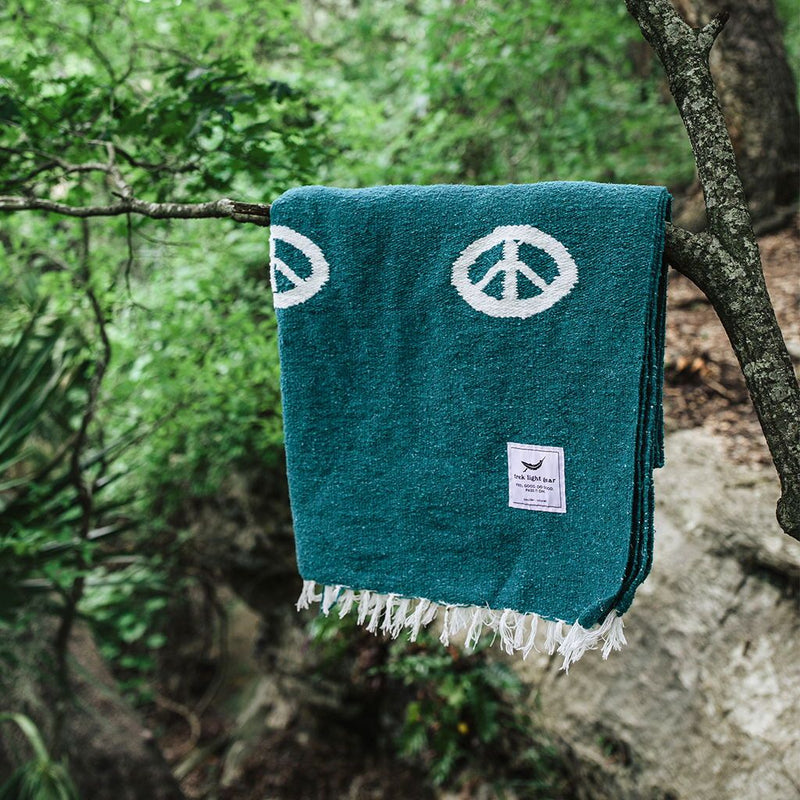 Trek Light Gear Teal Peace Blanket--hanging on a tree branch