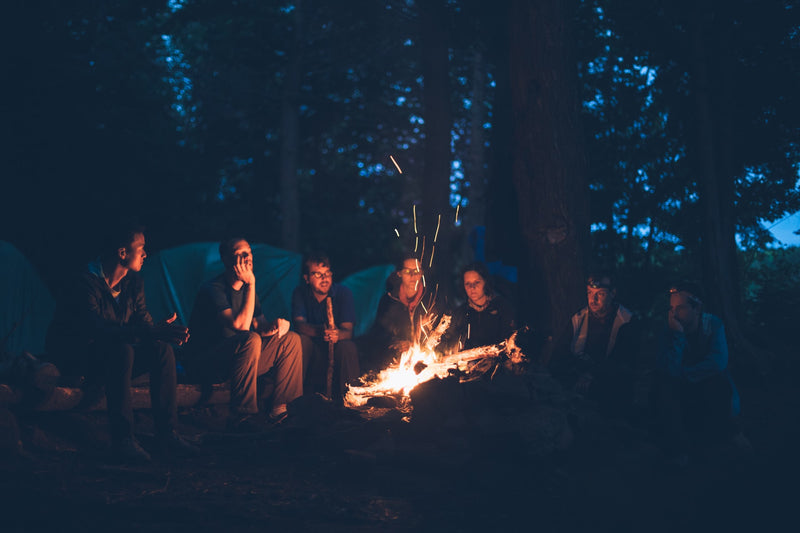 A group of people around a campfire at night