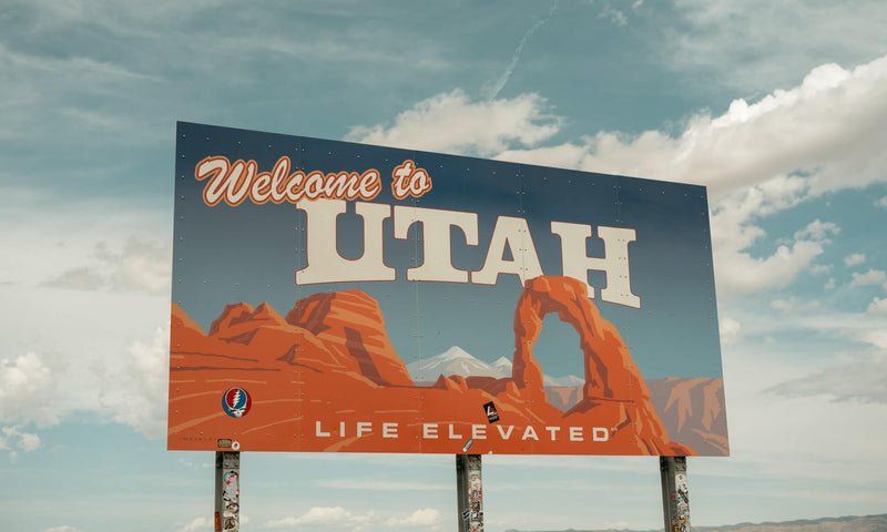 welcome to utah sign with clouds