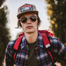 A man wears Eagle Aluminum sunglasses on a forest trek.