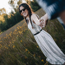 A woman in a field of flowers wears wilder eco matte black shades.