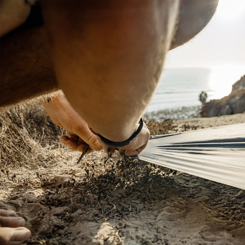 Matador Pocket Blanket 3.0--putting the ground stake into the sand