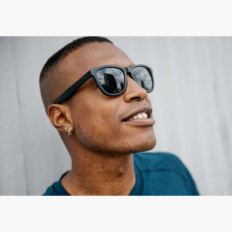 Knockaround Black on Black Smoke Premium Sunglasses on a male model looking up and smiling