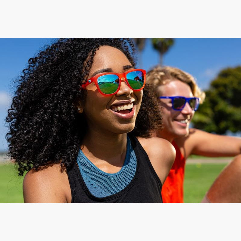 Knockaround Fruit Punch Aqua Sport Sunglasses on a woman in the park