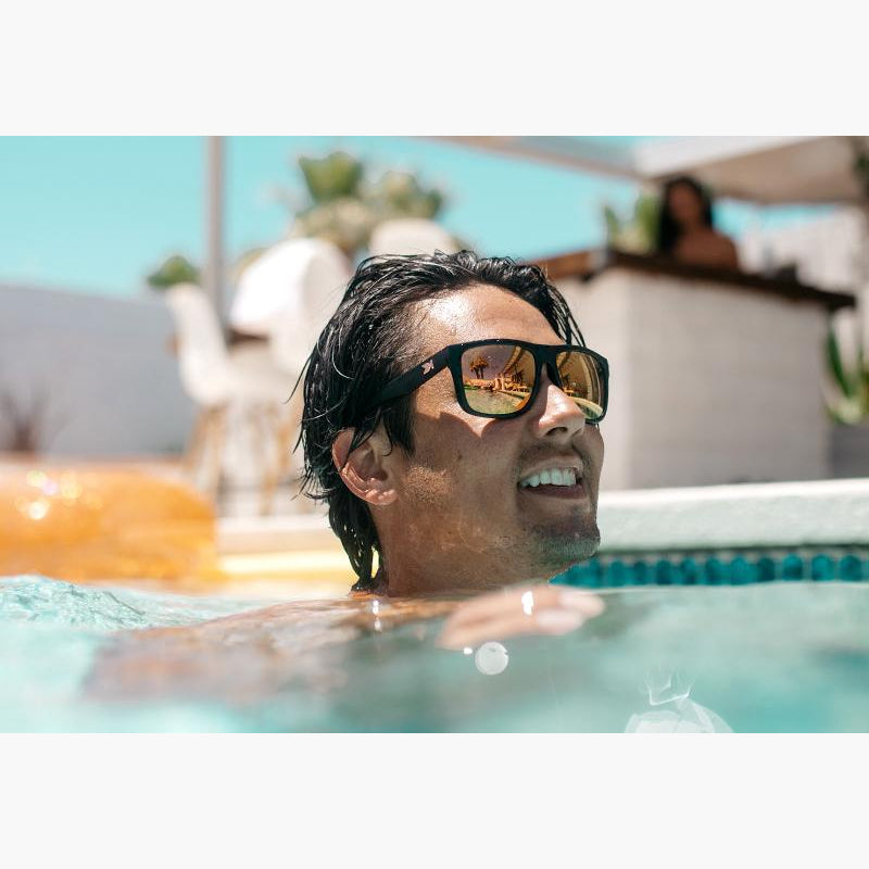 knockaround matte black rose gold Torrey Pines sunglasses on a man in a swimming pool