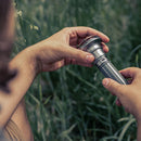 Man holding flashlight near campsite