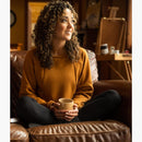 DESO Leland Pullover Desert Camel--girl sitting on a couch with coffee