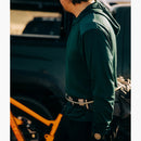 Deso Supply Company Yuba Long Sleeve Hoodie side view of a male mountain biker looking at his bike