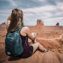 A woman wears the DL16 Backpack at Red Rocks.