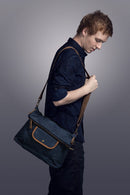 A man carries the Hobo Canvas Messenger Bag.