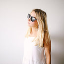 A woman wears the Scout Eco Black/Polarized lens sunglasses from Proof to a photoshoot.