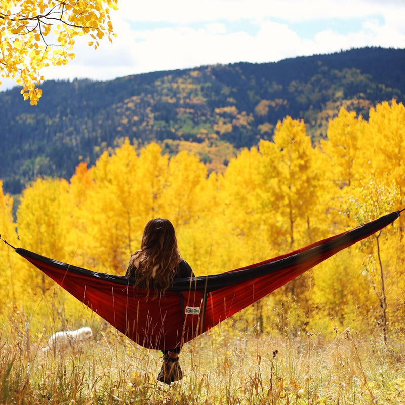 Trek Light Red and Charcoal Double Hammock--girl staring at yellow fall leaves